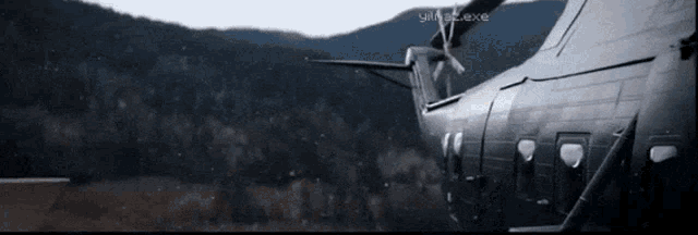 a black airplane is sitting in front of a mountain with a watermark that says ' yilla2exe ' on it