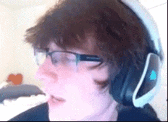 a person wearing glasses and headphones is making a funny face .