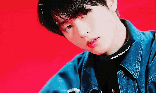 a close up of a young man wearing a denim jacket and a black sweater that says " adding girls to pop "