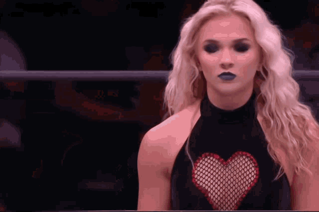a woman wearing a black top with a red heart on it