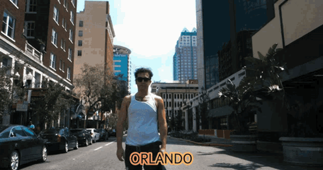 a man in a white tank top is walking down a city street with orlando written on the side
