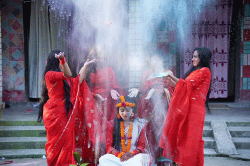 a group of women in red dresses are standing around a bride