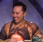 a man wearing a shirt with a picture of a man 's face on it is smiling .
