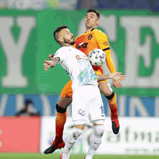 a soccer player wearing a white jersey with the number 10 on it jumps in the air