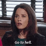 a woman is sitting in front of a window and saying `` go to hell . ''