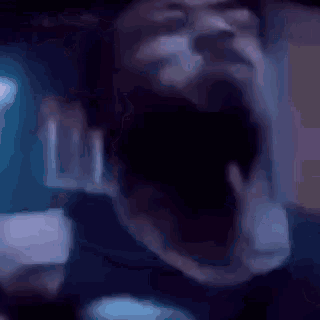 a close up of a man 's face with his eyes closed and his mouth open .