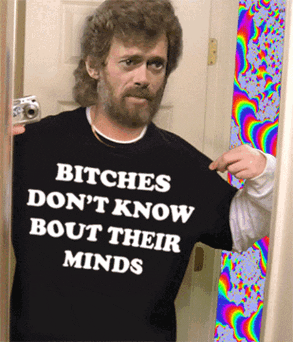 a man with a beard wearing a shirt that says bitches don 't know bout their minds