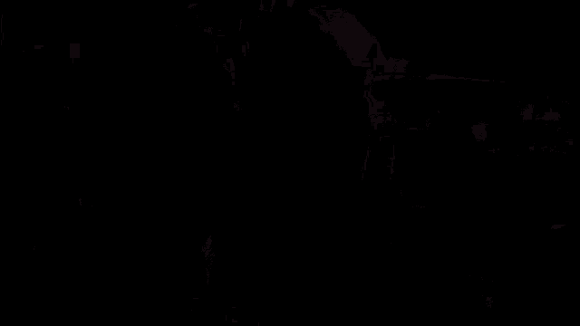 a man and a woman are standing next to each other in the dark .