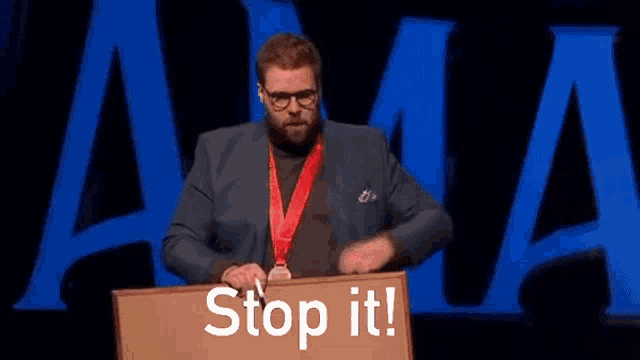 a man with a medal around his neck is standing at a podium with the words stop it written on it