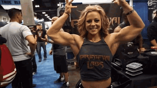 a woman is flexing her muscles in front of a sign that says true blue