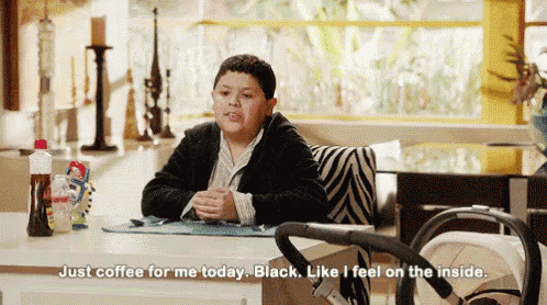 a young boy is sitting at a table with a stroller and says just coffee for me today black like i feel on the inside