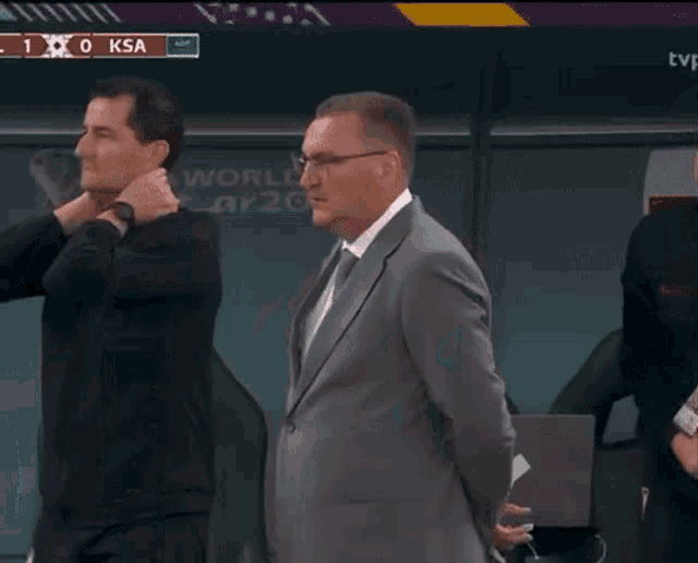 a group of men are standing in front of a scoreboard that says ksa on it