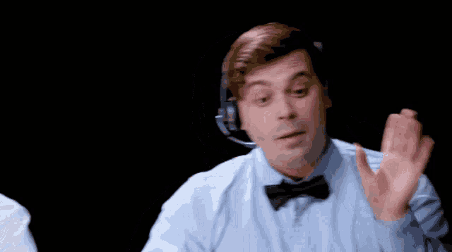 a man wearing headphones and a bow tie is making a funny face