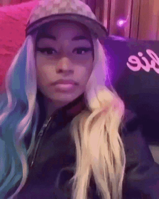 a woman with blue and white hair is wearing a hat and a jacket .