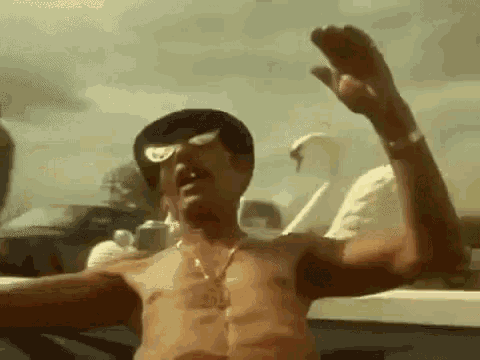 a shirtless man wearing sunglasses and a hat is standing with his arms outstretched .