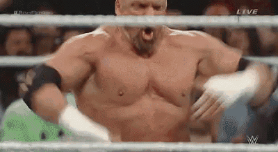 a man without a shirt is standing in a wrestling ring with his mouth open and wrapped in bandages .