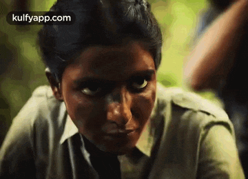 a close up of a woman 's face with a serious look on her face
