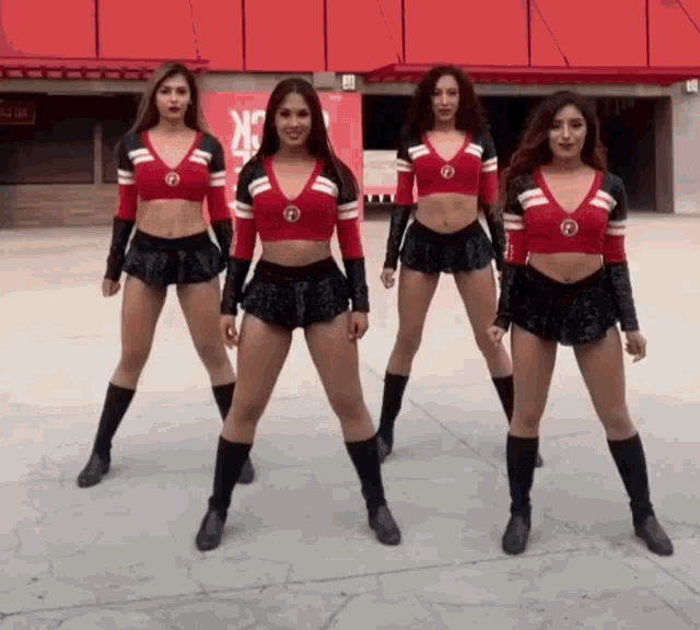 a group of cheerleaders are dancing in front of a building that says x on it