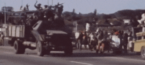 a blurred image of a military vehicle with soldiers on top
