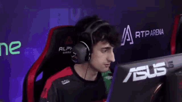 a man wearing a headset and a microphone is sitting in front of a computer monitor .