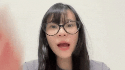 a woman wearing glasses is making a funny face and looking at the camera .
