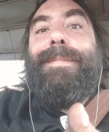 a man with a beard wearing a patriots shirt