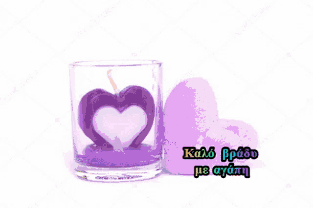 there is a purple heart shaped candle in a glass next to a purple heart shaped pillow .