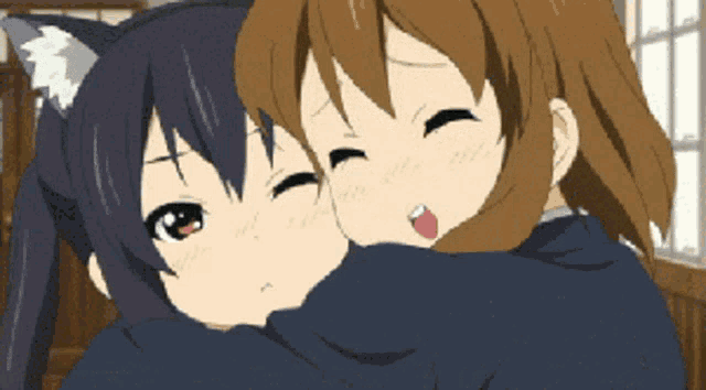 a girl with cat ears is hugging another girl with brown hair