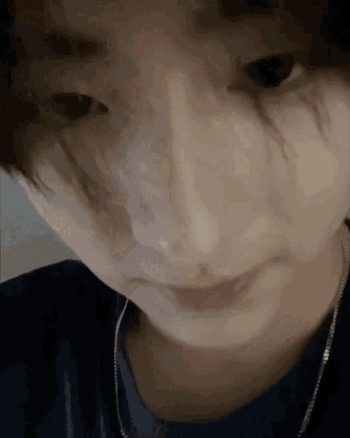 a close up of a person 's face wearing a blue shirt