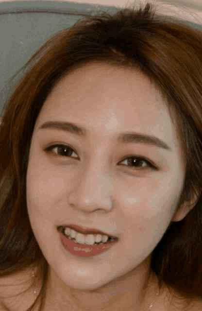 a close up of a woman 's face with a smile