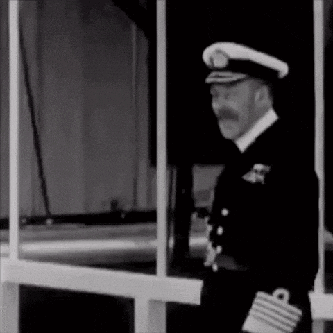 a man in a military uniform with a mustache is standing in front of a window .