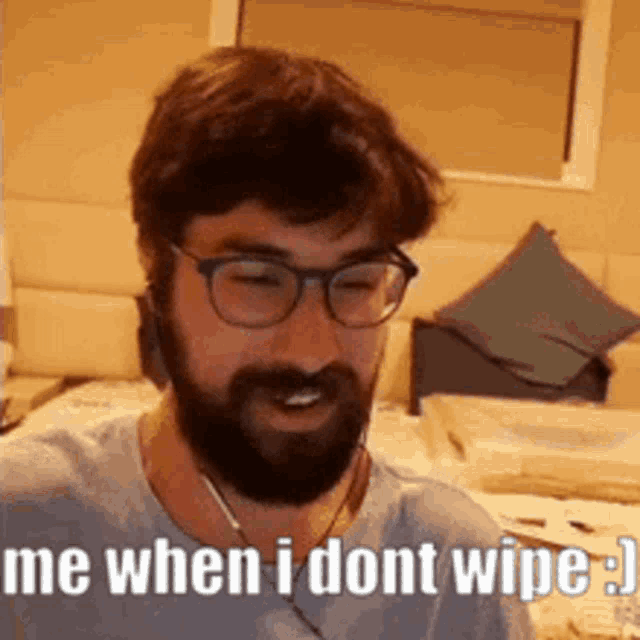 a man with a beard and glasses is wearing headphones and says `` me when i dont wipe . ''