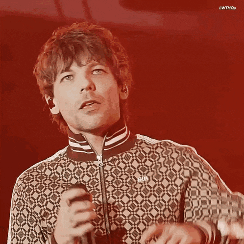a man singing into a microphone with the word h & m on his shirt