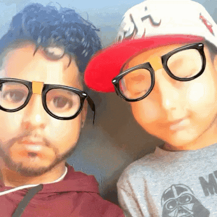 a man wearing glasses and a boy wearing a hat with the letter j on it