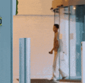 a man standing in front of a round glass door