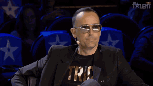 a man wearing glasses and a shirt that says trio