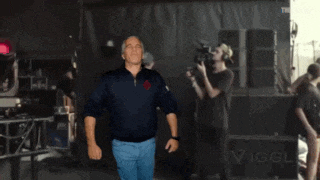 a man in a blue shirt stands in front of a large black box that says tcl