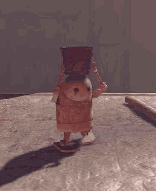 a robot with a bucket on its head is standing on a concrete floor .