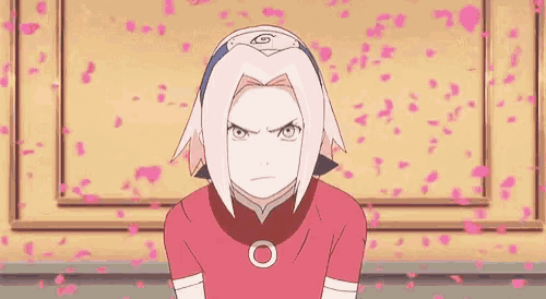 a girl with pink hair is sitting in front of a wall with pink flowers falling around her .