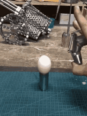 a person is holding a white ball on a cutting mat