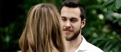 a man with a beard is looking at a woman .