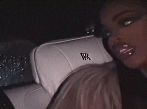 a woman is sitting in the back seat of a white rolls royce .