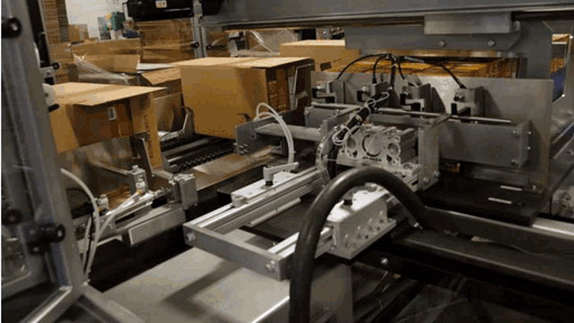 cardboard boxes are being loaded into a machine that says amazon on the side
