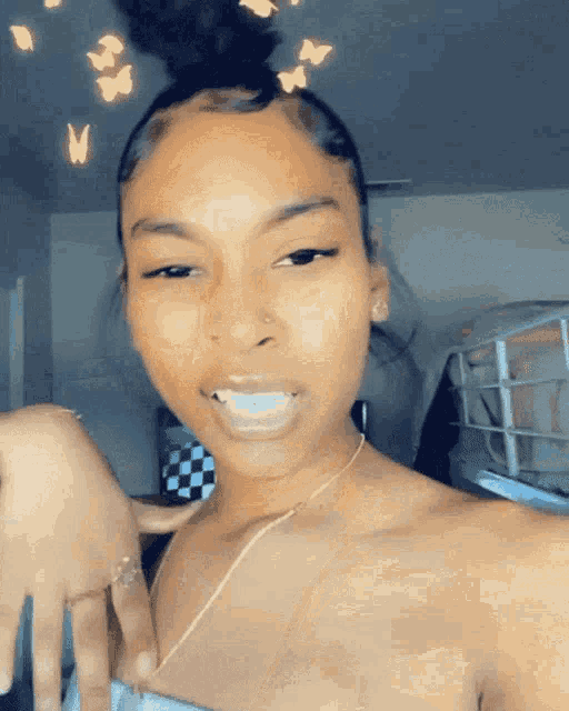 a woman is taking a selfie with a butterfly filter on her hair .