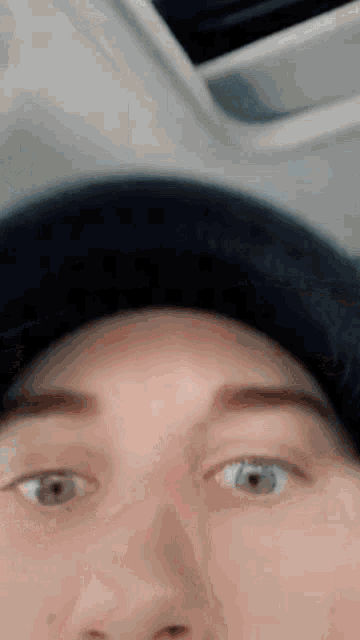 a close up of a person 's face with a blue hat on .