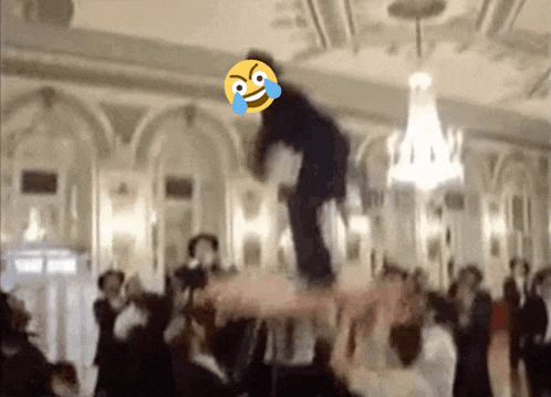 a group of people are dancing in a large room with a smiley face on the ceiling
