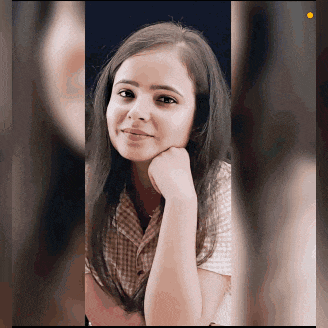 a young woman with her hand on her chin looks at the camera