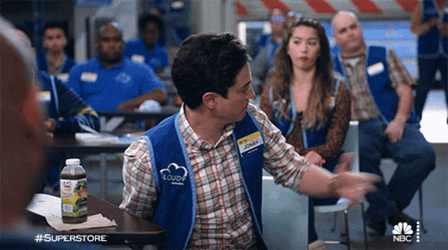 a man wearing a superstore vest that says jonathan on it
