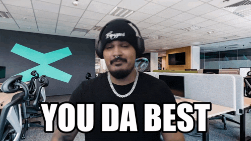 a man wearing headphones and a hat says " you da best "