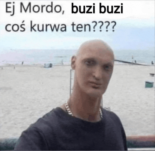 a bald man is taking a selfie on a beach with a foreign language caption .